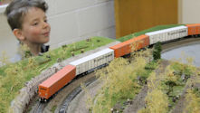 A scenic river bridge with a model train passing over the water.
