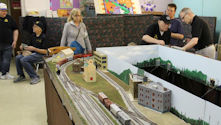 A diesel locomotive moving through a desert-themed railway layout.