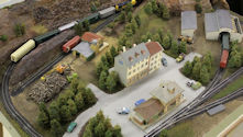 A detailed model railway featuring an urban landscape with skyscrapers and railway stations.