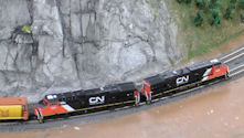 A countryside model railway featuring a traditional farm with a train passing by.