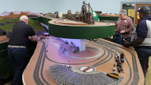 A modern passenger train traveling through an urban model railway setup.