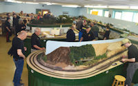A model railway featuring a high-speed train passing through a tunnel.