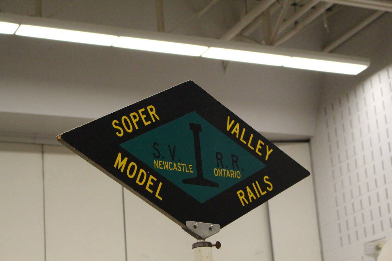 A diamond-shaped sign reading 'Soper Valley Model Rails' with 'S.V.R.R.' and 'Newcastle, Ontario' in the center.
