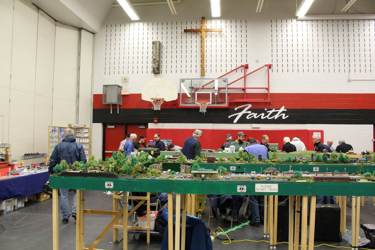 Miniature model of Die Craft Manufacturing, featuring a brick factory, parked trucks, workers, and railway tracks in a detailed model railroad layout.