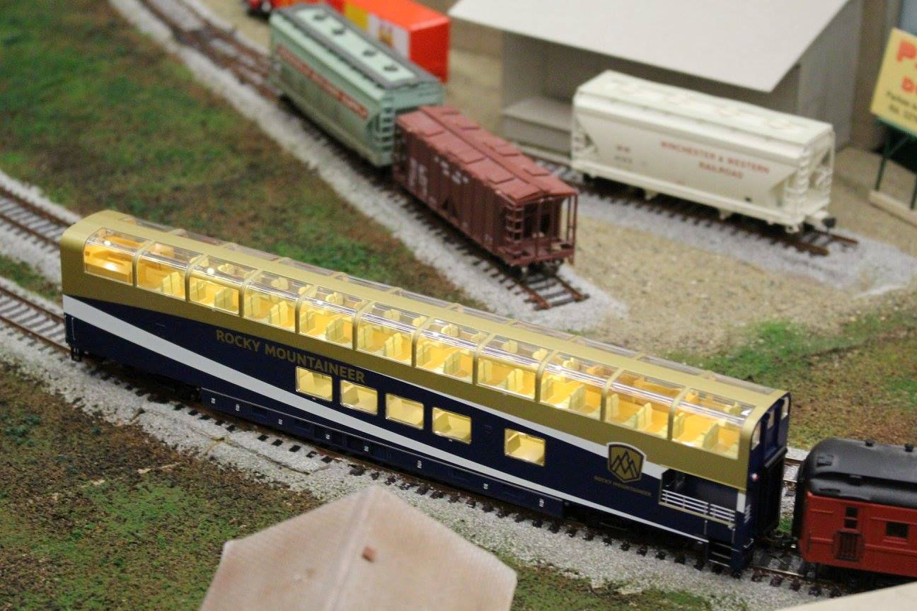 Rocky Mountaineer model train car with glass dome and interior lights on a model railway
