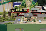 A railway tunnel entrance with a train emerging into a lush countryside landscape.
