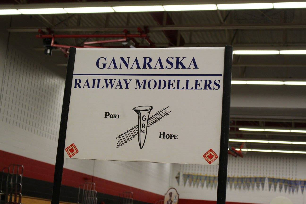Ganaraska Railway Modellers sign featuring a railroad spike and track illustration, representing the model railroad club from Port Hope.