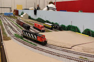 Freight train crossing a steel bridge with realistic terrain.