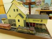 Train yard with maintenance sheds and locomotives.