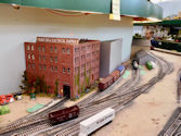 A model railway featuring a city skyline with a train passing through.