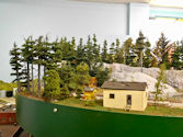 A countryside railway layout featuring a farm and vintage train station.
