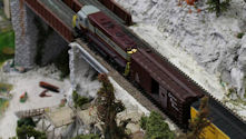 An industrial railway yard featuring cargo containers and switching locomotives.